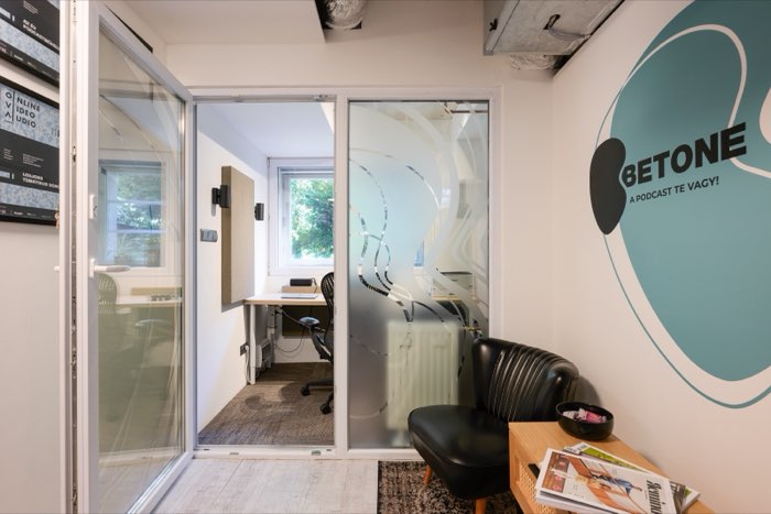 The waiting area with a black armchair, a Betone logo on the wall and an office behind the glass door.