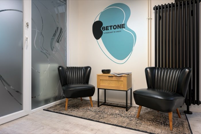 The waiting area: two black armchairs and a side table, with the Betone logo on the wall.